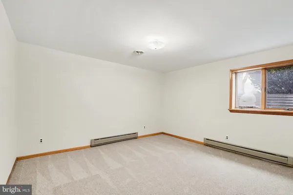 an empty room with a ceiling fan and a window