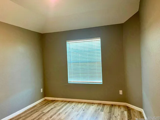 a view of a room with wooden floor and a window