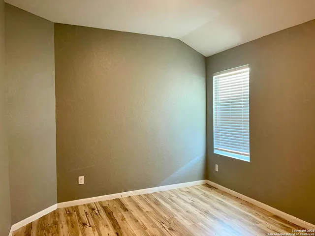 a view of a room with wooden floor and a window