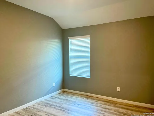 a view of a room with wooden floor and a window