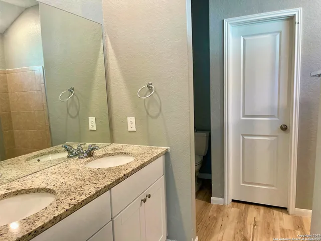 a bathroom with a granite countertop sink and a mirror