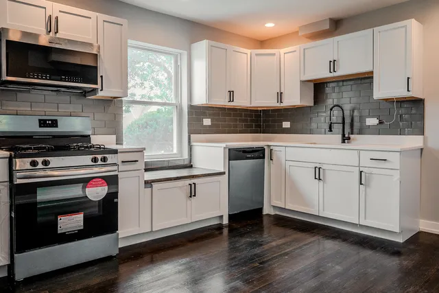 a kitchen with stainless steel appliances a stove a sink and a microwave