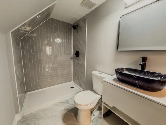 a bathroom with a toilet and a shower
