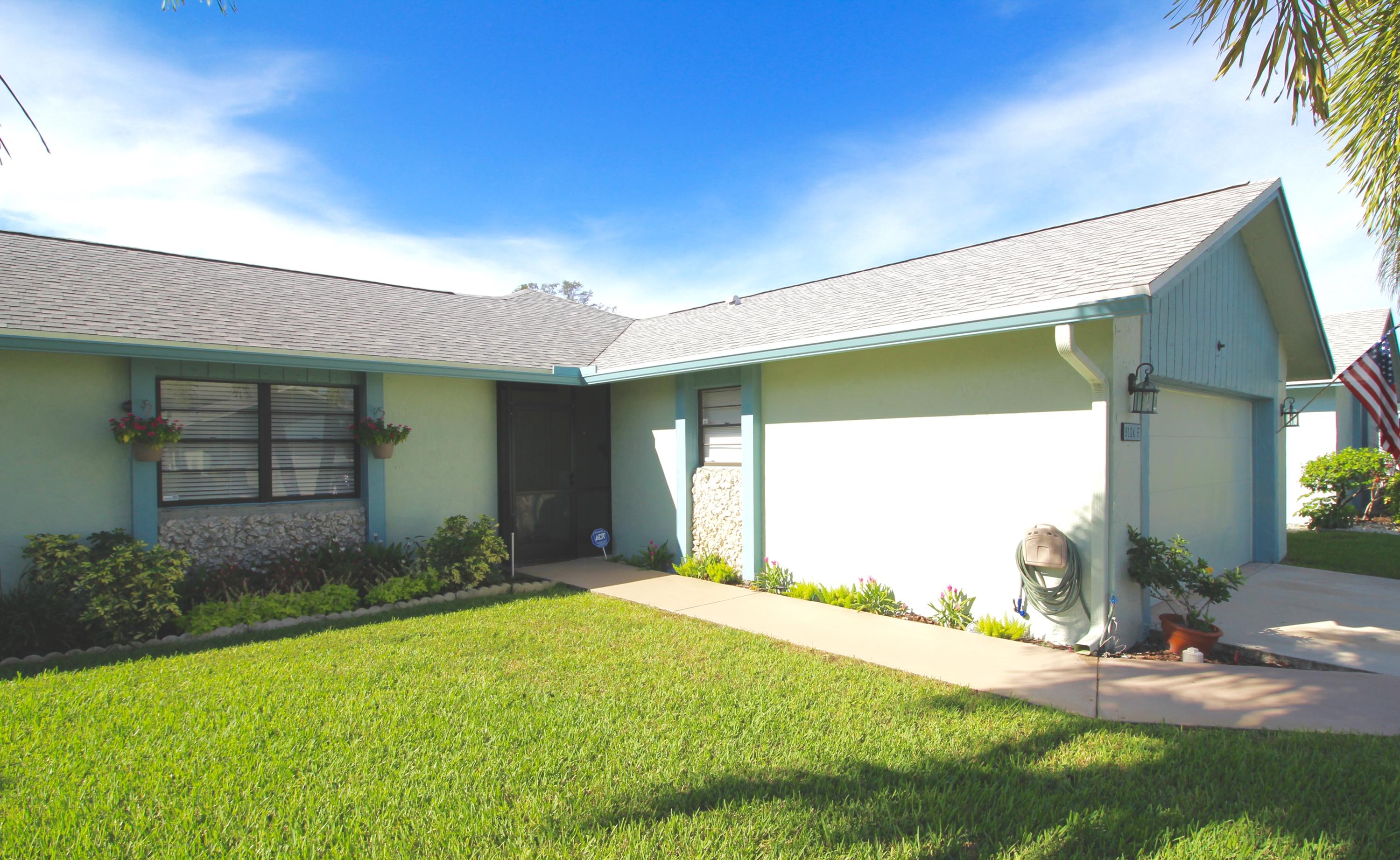 9124 Southwest 22nd Street, Unit F Boca Raton, FL 33428 - Photo 3 of 19 a front view of a house with a yard
