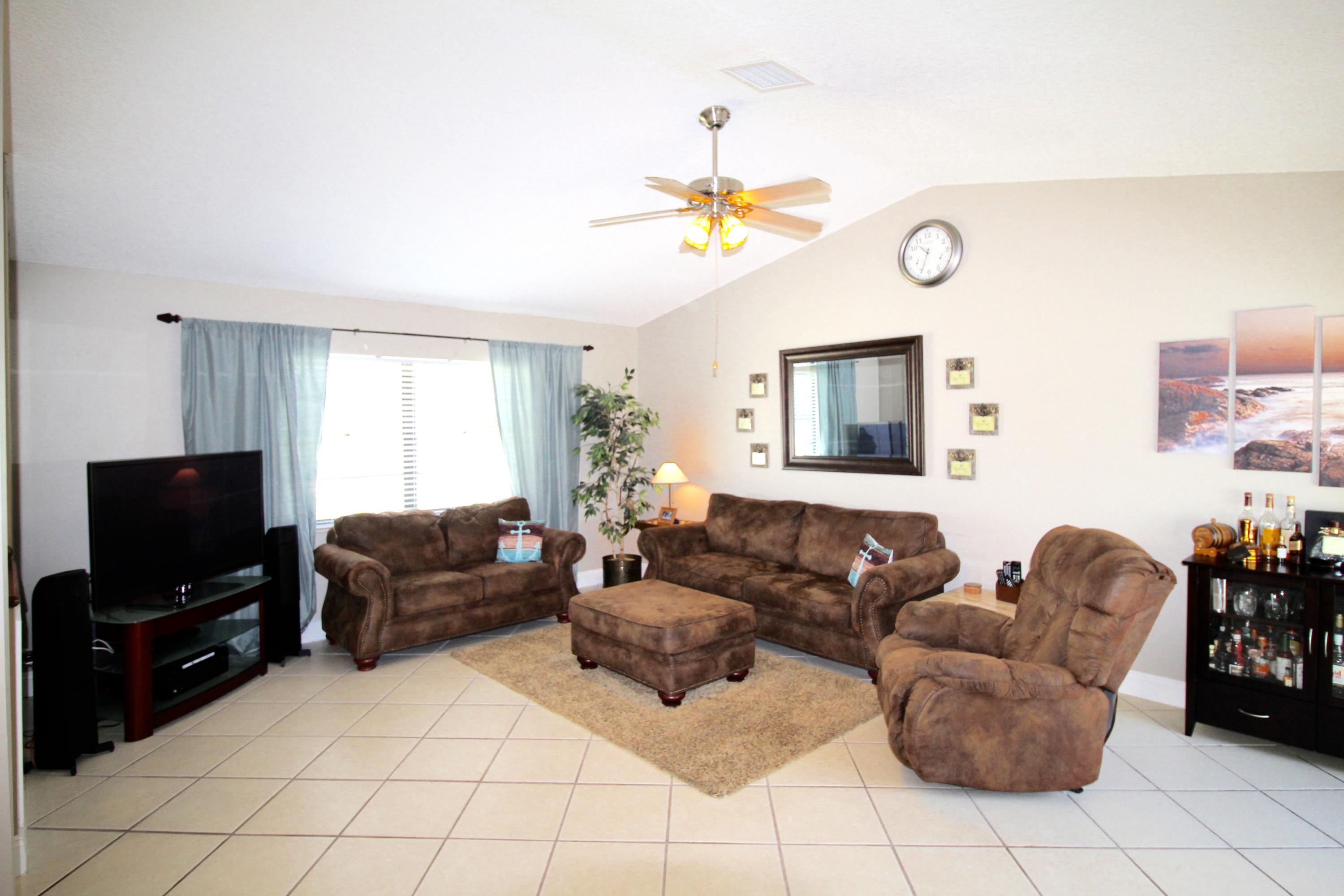9124 Southwest 22nd Street, Unit F Boca Raton, FL 33428 - Photo 8 of 19 a living room with furniture and a flat screen tv