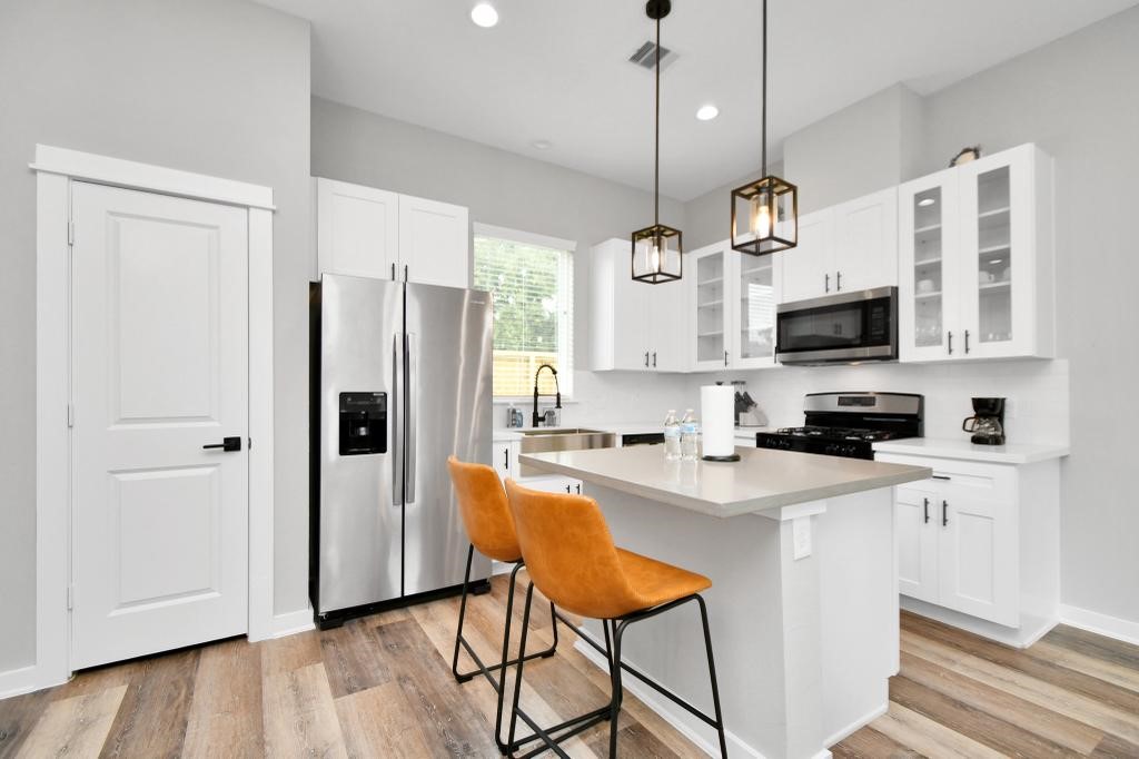 407 Stonework Oaks Lane Houston, TX 77076 - Photo 22 of 34 a kitchen with stainless steel appliances granite countertop a refrigerator a stove a sink dishwasher a dining table and chairs with wooden floor