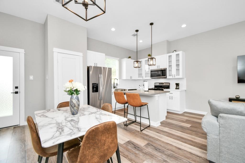 407 Stonework Oaks Lane Houston, TX 77076 - Photo 23 of 34 a kitchen with stainless steel appliances kitchen island granite countertop a table chairs and a refrigerator