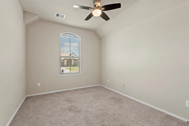 an empty room with windows and fan