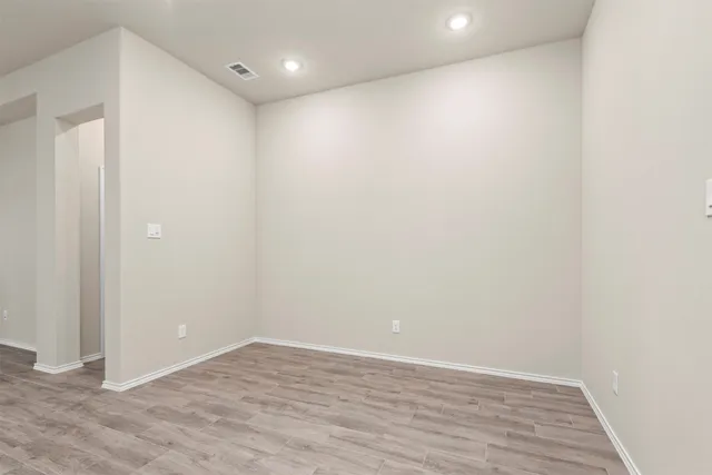 a view of an empty room with wooden floor
