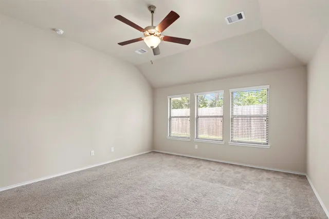an empty room with a window and a fan