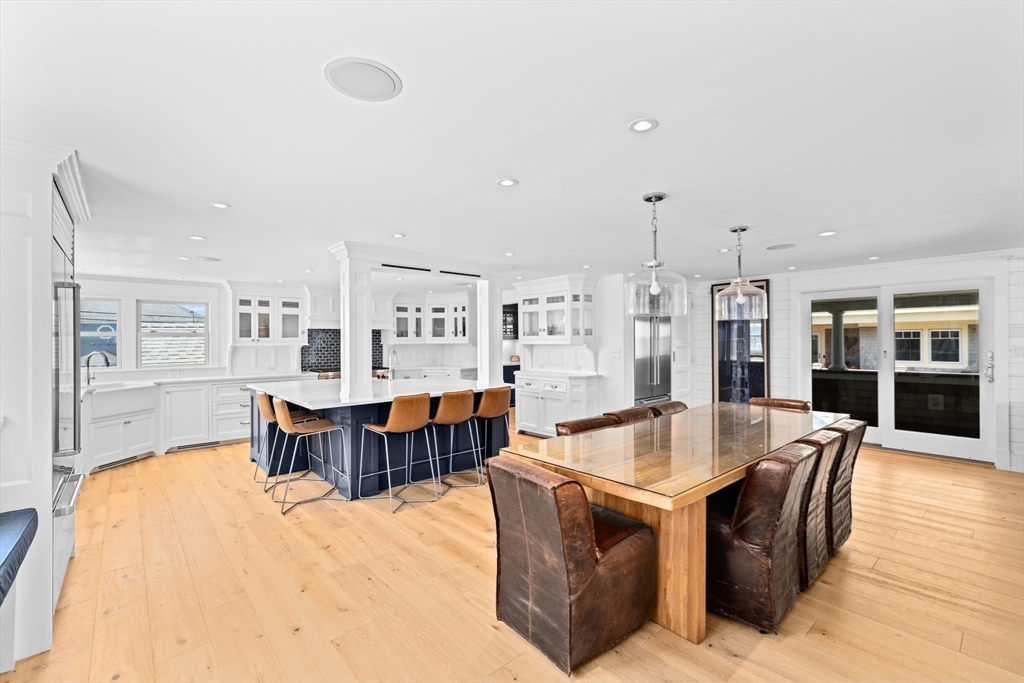 57 Surfside Road Scituate, MA 02066 - Photo 22 of 39 a large living room with stainless steel appliances kitchen island granite countertop a table chairs and a refrigerator