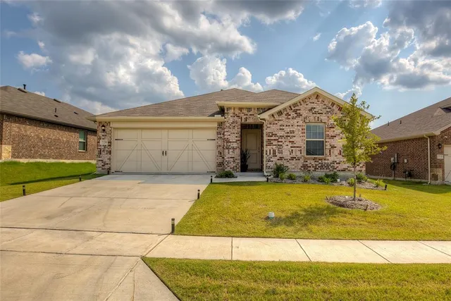 a front view of a house with a yard garage and outdoor seating