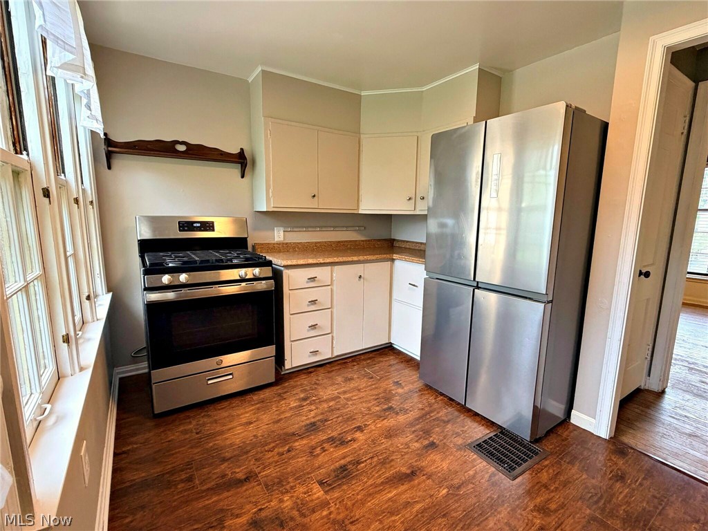 210 Callahan Road Canfield, OH 44406 - Photo 14 of 34 Stainless steel appliances, wood-finish flooring, white cabinetry, and a corner counter space