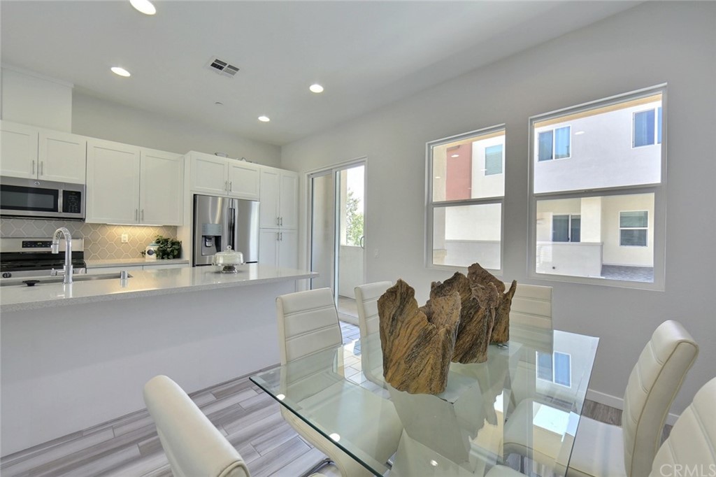 714 Brooklyn Drive Brea, CA 92821 - Photo 11 of 31 a kitchen with stainless steel appliances granite countertop a table chairs and a refrigerator