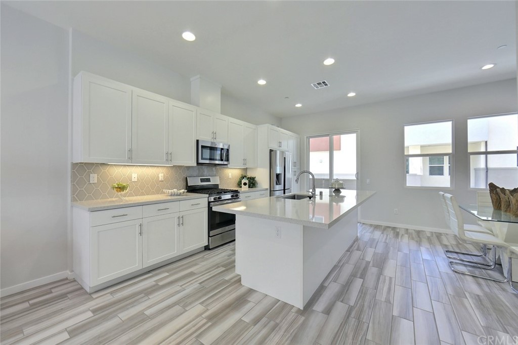 714 Brooklyn Drive Brea, CA 92821 - Photo 7 of 31 a kitchen with white cabinets appliances and wooden floor