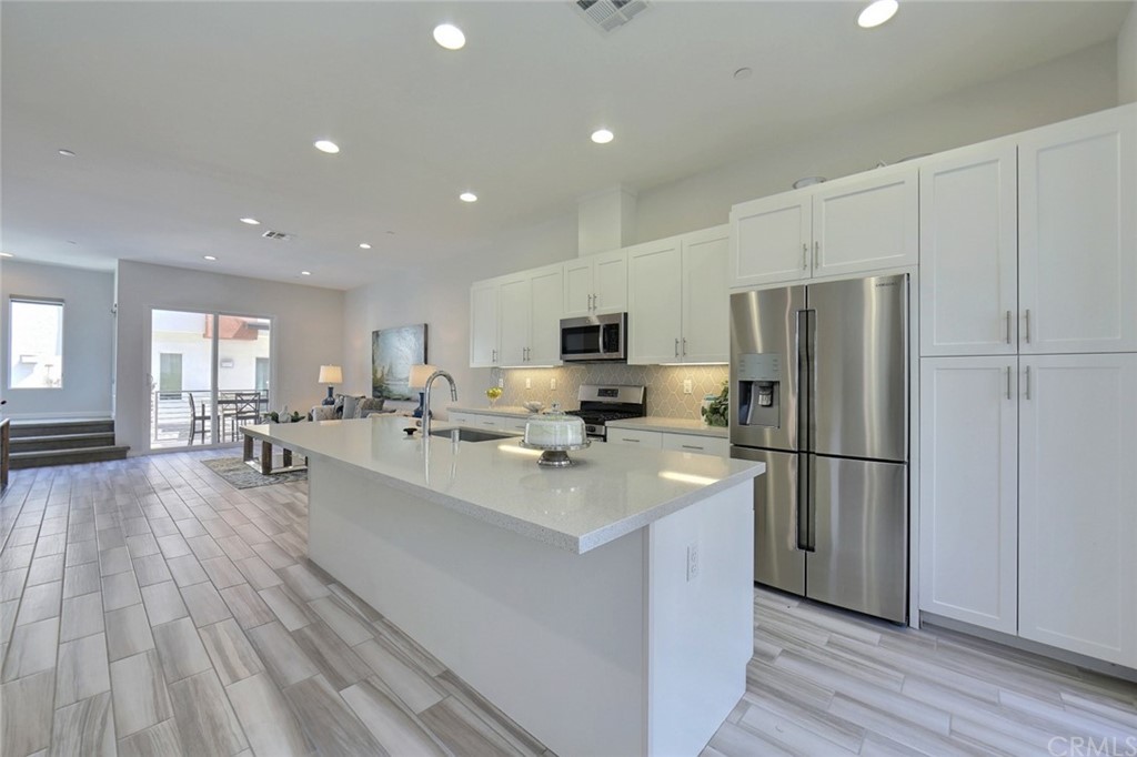 714 Brooklyn Drive Brea, CA 92821 - Photo 8 of 31 a kitchen with refrigerator a stove a sink a dining table and chairs with wooden floor