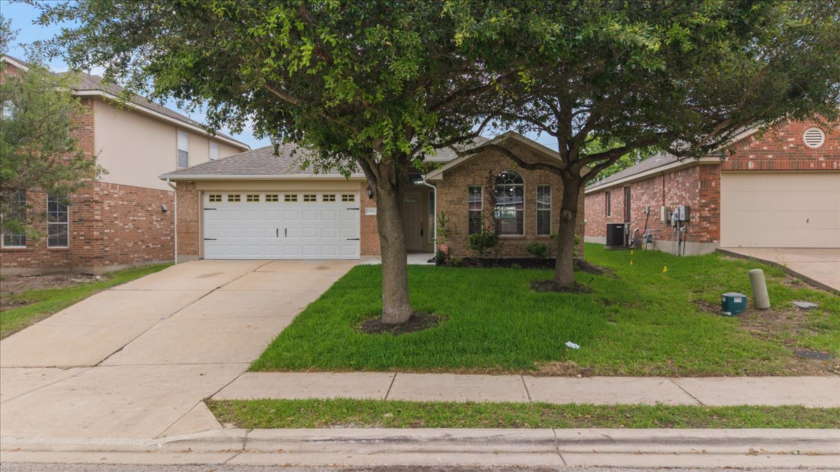 Single-story residence featuring a brick and stucco exterior, an attached garage, and a concrete driveway