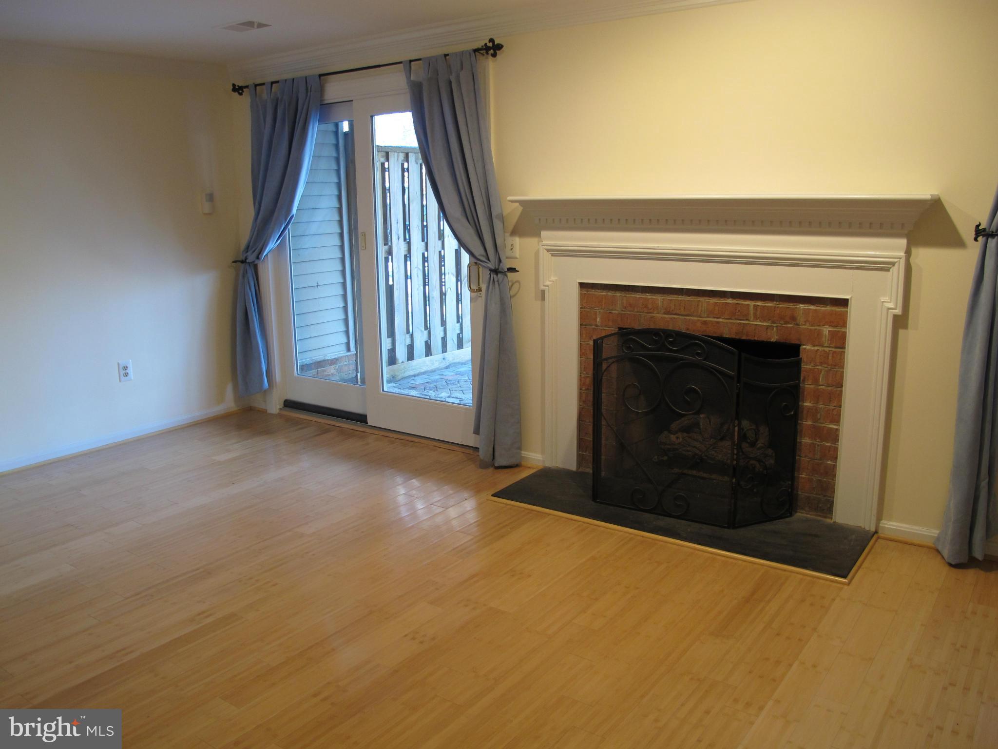 7726 Asterella Court Springfield, VA 22152 - Photo 17 of 22 a view of an empty room with wooden floor fireplace and a window