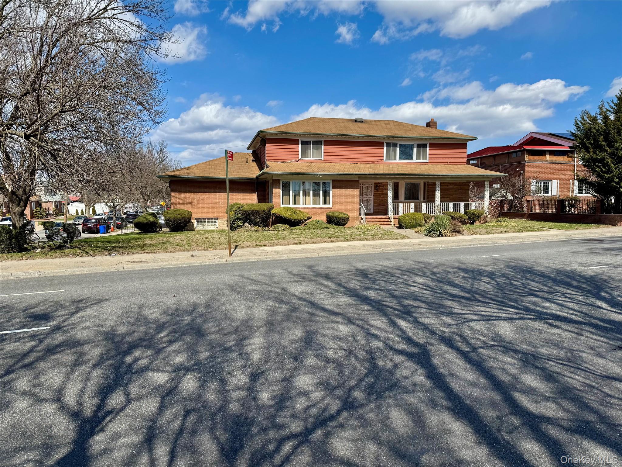a view of a big house with a big yard and large trees