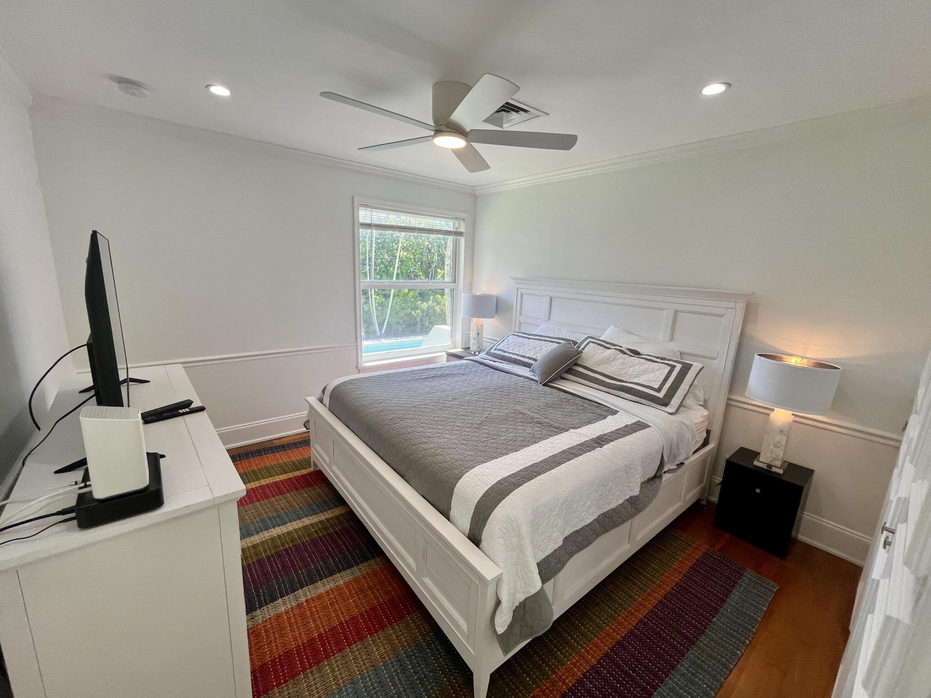 115 Dolphin Road Ocean Ridge, FL 33435 - Photo 14 of 38 a bedroom with a bed and a flat screen tv