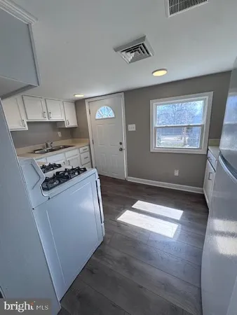 a kitchen with kitchen island a stove a sink and a refrigerator