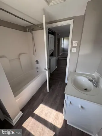 a bathroom with a tub a sink and a mirror