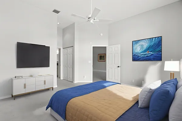 a bedroom with a bed flat screen tv and a window