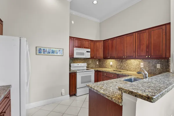 a kitchen with granite countertop stainless steel appliances a sink window and cabinets