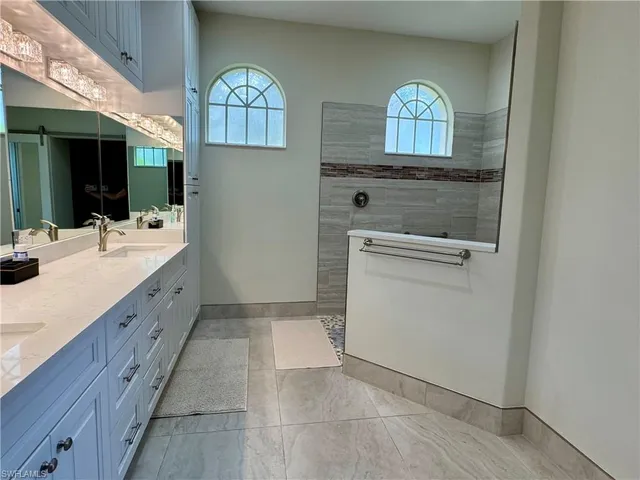 a spacious bathroom with double vanity and a mirror