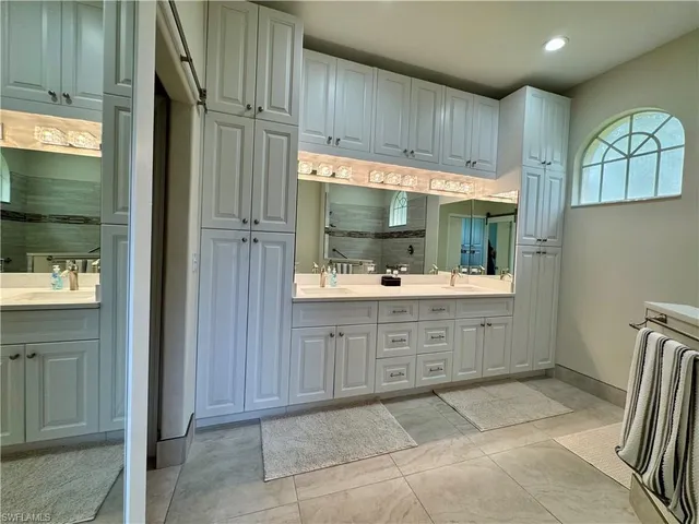 a kitchen with white cabinets and refrigerator