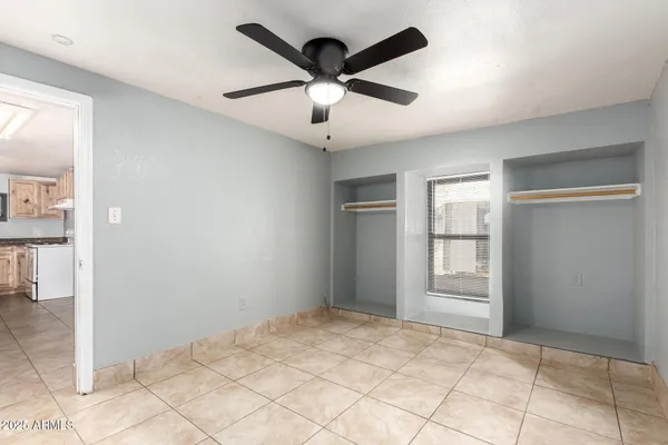 a view of empty room with window and ceiling fan