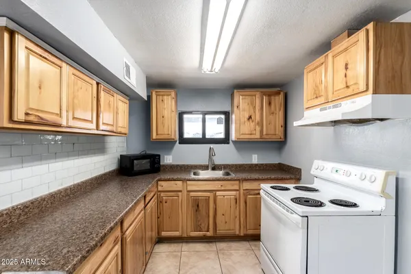 a kitchen with a stove a sink and a cabinets