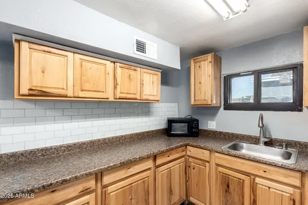 a kitchen with stainless steel appliances granite countertop a sink and a cabinets next to a window