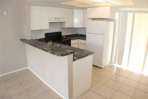 a kitchen with a refrigerator a stove a microwave and cabinets