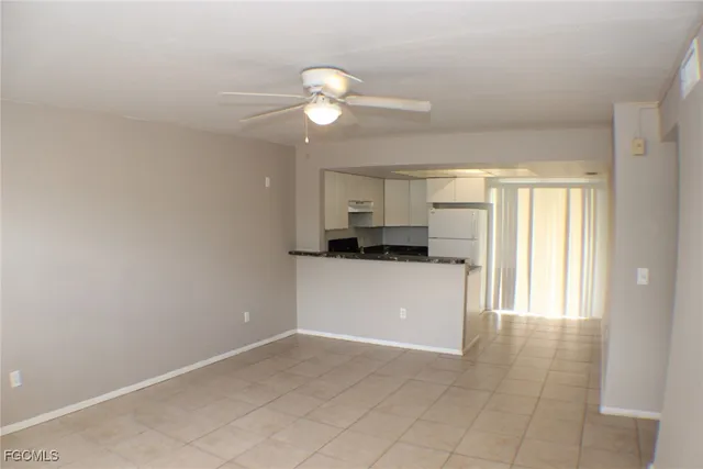 a kitchen with a refrigerator and white cabinets