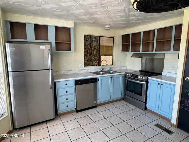 a kitchen with stainless steel appliances granite countertop a refrigerator and a stove top oven