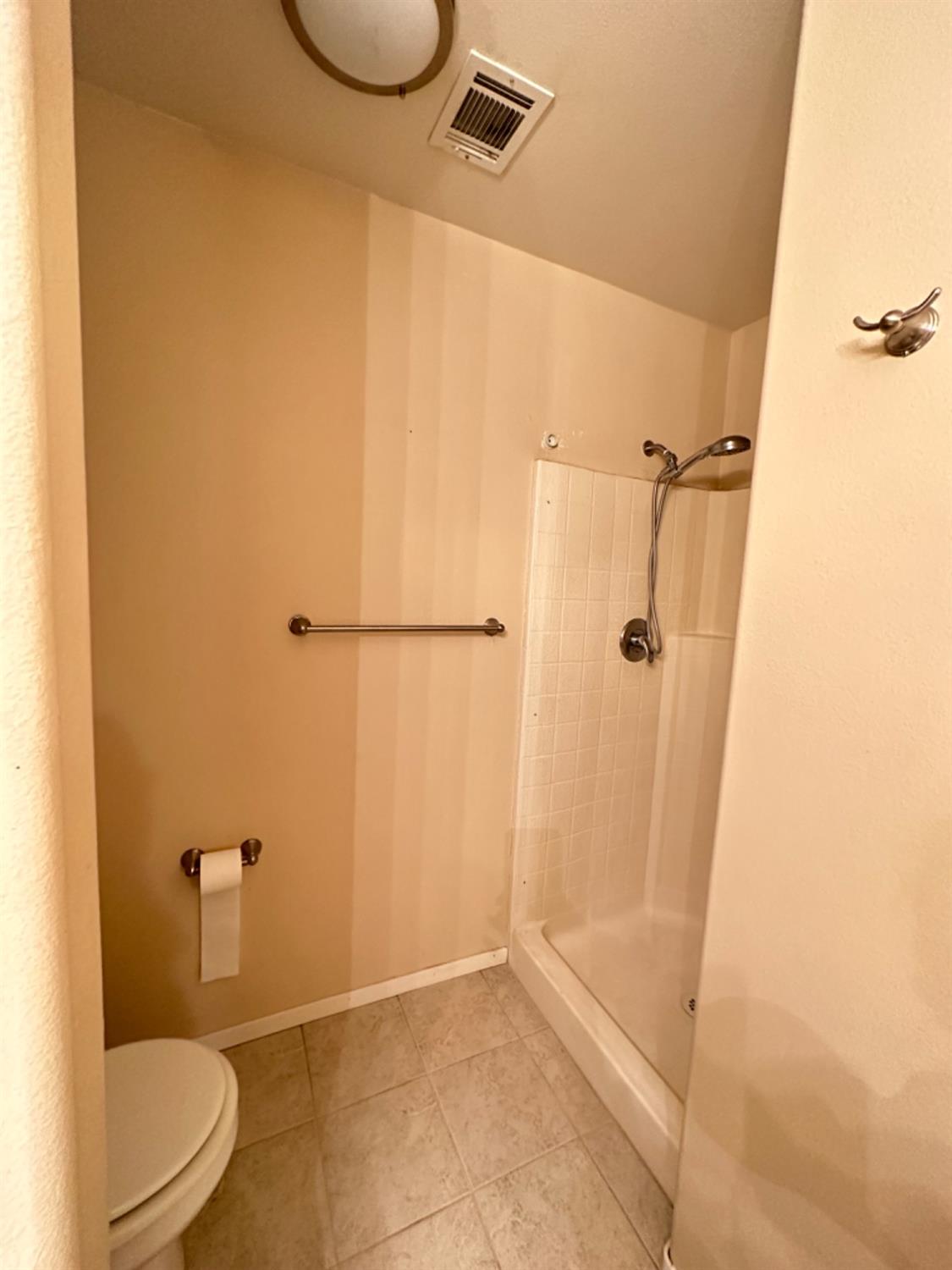 596 Grenache Avenue Madera, CA 93637 - Photo 17 of 26 a bathroom with a granite countertop shower and a toilet