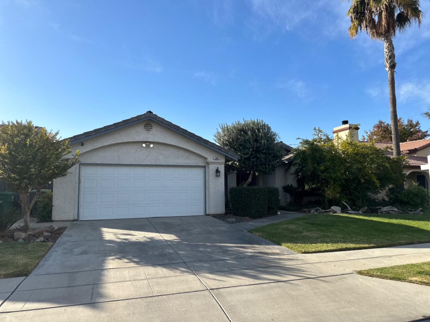 596 Grenache Avenue Madera, CA 93637 - Photo 25 of 26 a front view of a house with a yard and garage