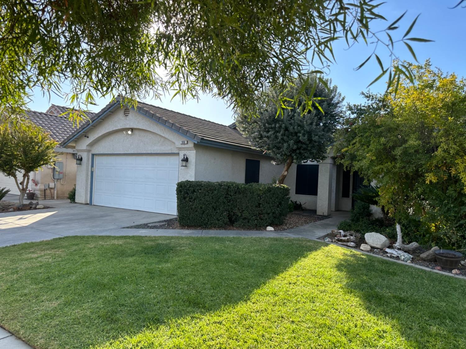 596 Grenache Avenue Madera, CA 93637 - Photo 26 of 26 a view of a house with a yard and a large tree
