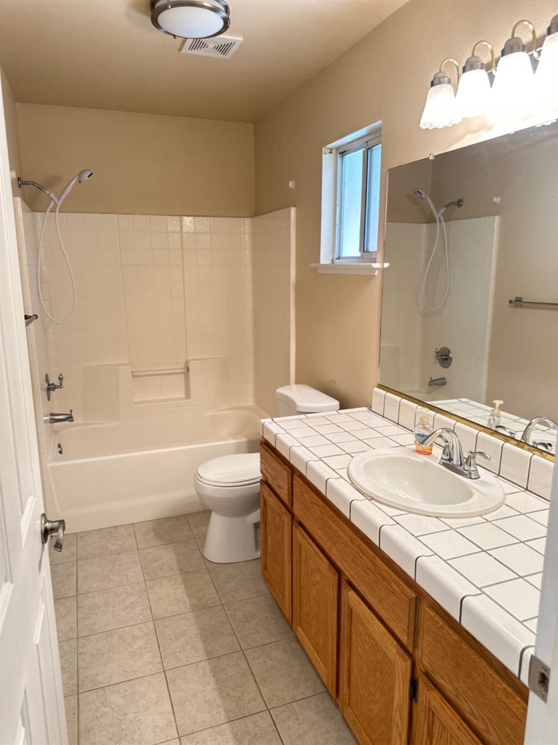 596 Grenache Avenue Madera, CA 93637 - Photo 6 of 26 a bathroom with a granite countertop sink a toilet and bathtub