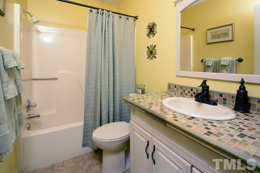 6013 Hampton Ridge Road Raleigh, NC 27603 - Photo 17 of 25 a bathroom with a granite countertop sink toilet and shower