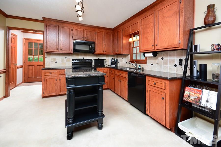 6013 Hampton Ridge Road Raleigh, NC 27603 - Photo 7 of 25 a kitchen with stainless steel appliances granite countertop wooden cabinets a stove top oven a granite counter top and a refrigerator