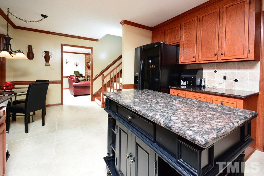 6013 Hampton Ridge Road Raleigh, NC 27603 - Photo 9 of 25 a kitchen with stainless steel appliances granite countertop a counter top space and wooden floor