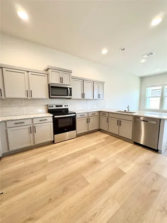a large kitchen with cabinets and stainless steel appliances
