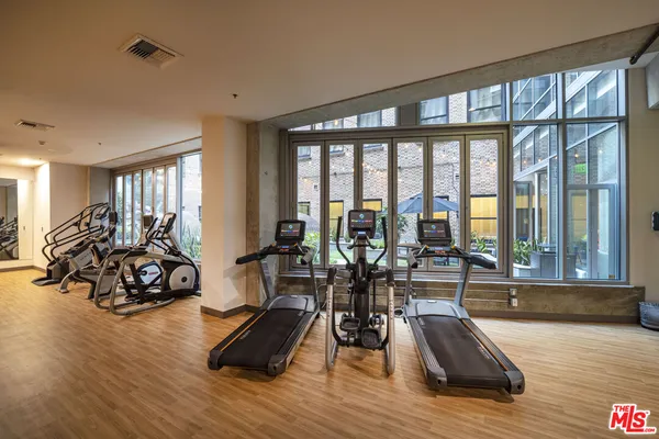 a view of a room with gym equipment and floor to ceiling window