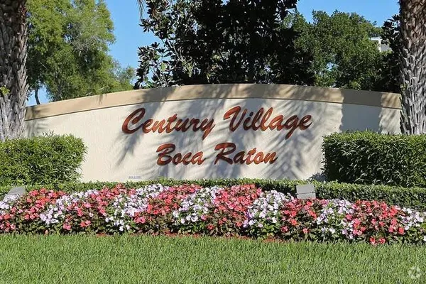 a view of a sign board with flower in front of it