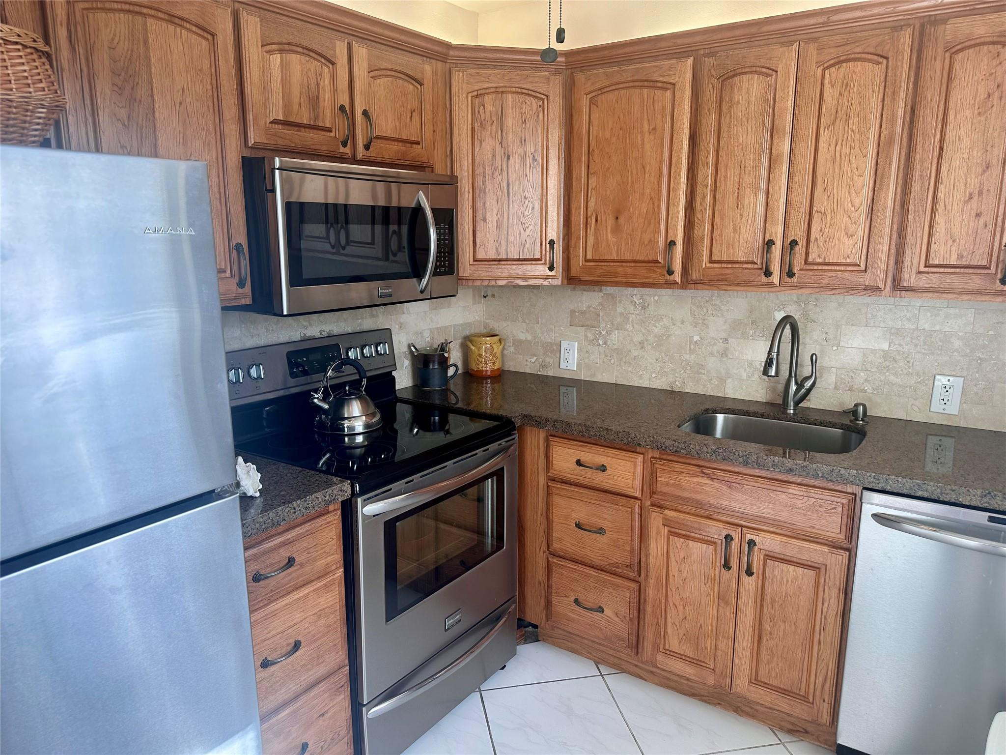 200 Mansfield F, Unit 200 Boca Raton, FL 33434 - Photo 3 of 15 a kitchen with stainless steel appliances granite countertop white cabinets a sink and dishwasher