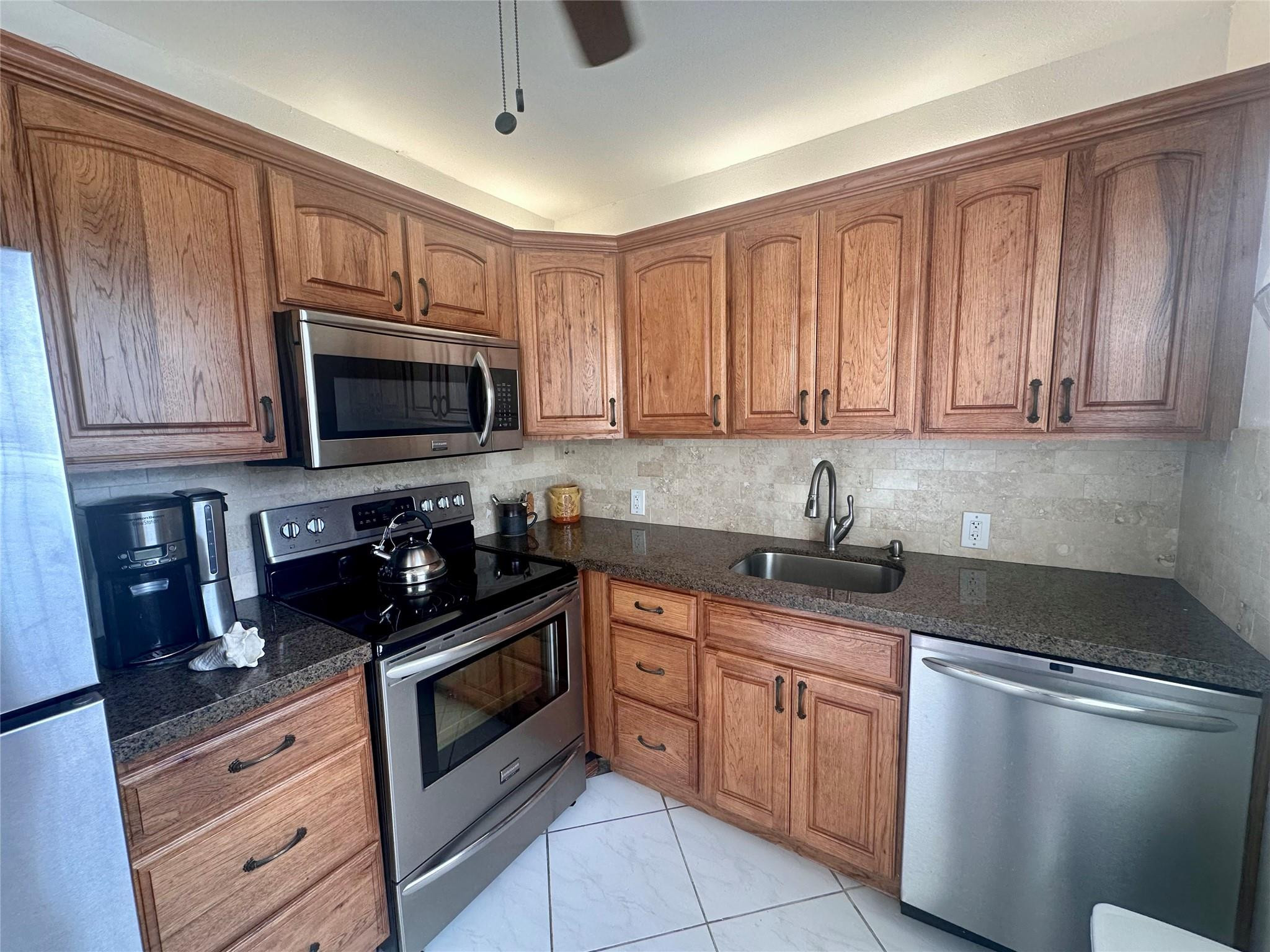 200 Mansfield F, Unit 200 Boca Raton, FL 33434 - Photo 4 of 15 a kitchen with a sink stove and microwave