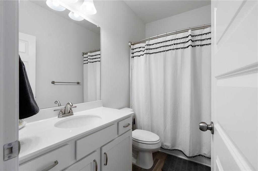 110 Waterside Ridgg Calhoun, GA 30701 - Photo 23 of 31 a bathroom with a sink a toilet a mirror and shower curtain