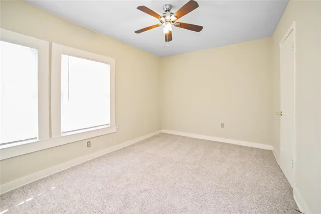 an empty room with a window and a fan